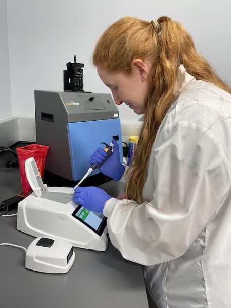 Brianna Stenger, PhD, loads a sample onto a DS-11 spectrophotometer.