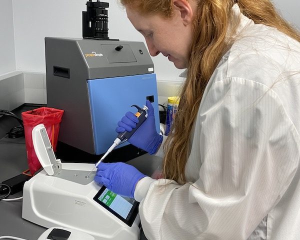 Brianna Stenger, PhD, loads a sample onto a DS-11 spectrophotometer.