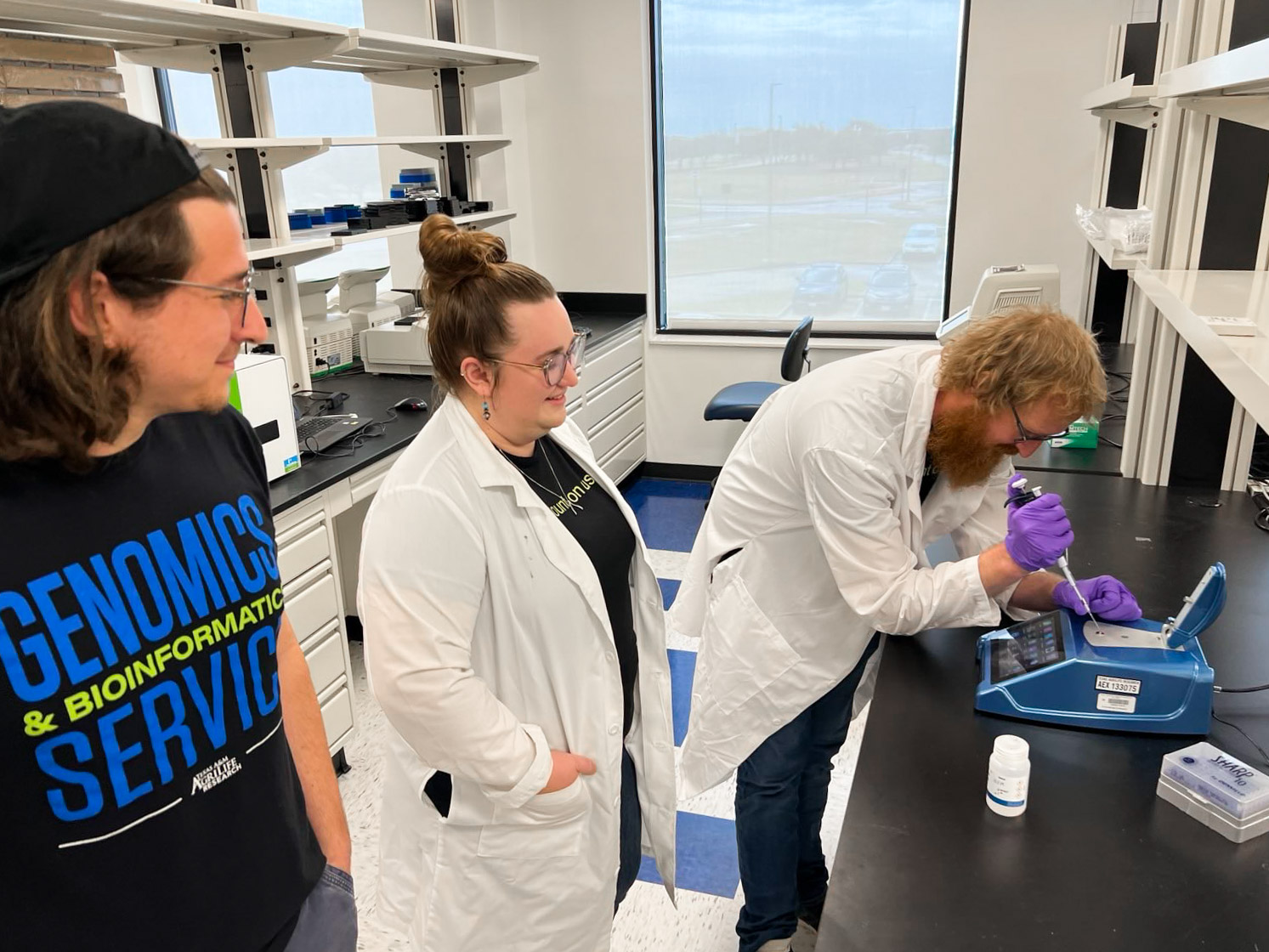 Scientists gather around a DS-11 Spectrophotometer at TxGen